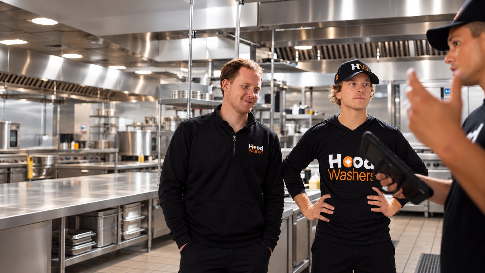 HoodWashers team members talking in a commercial kitchen