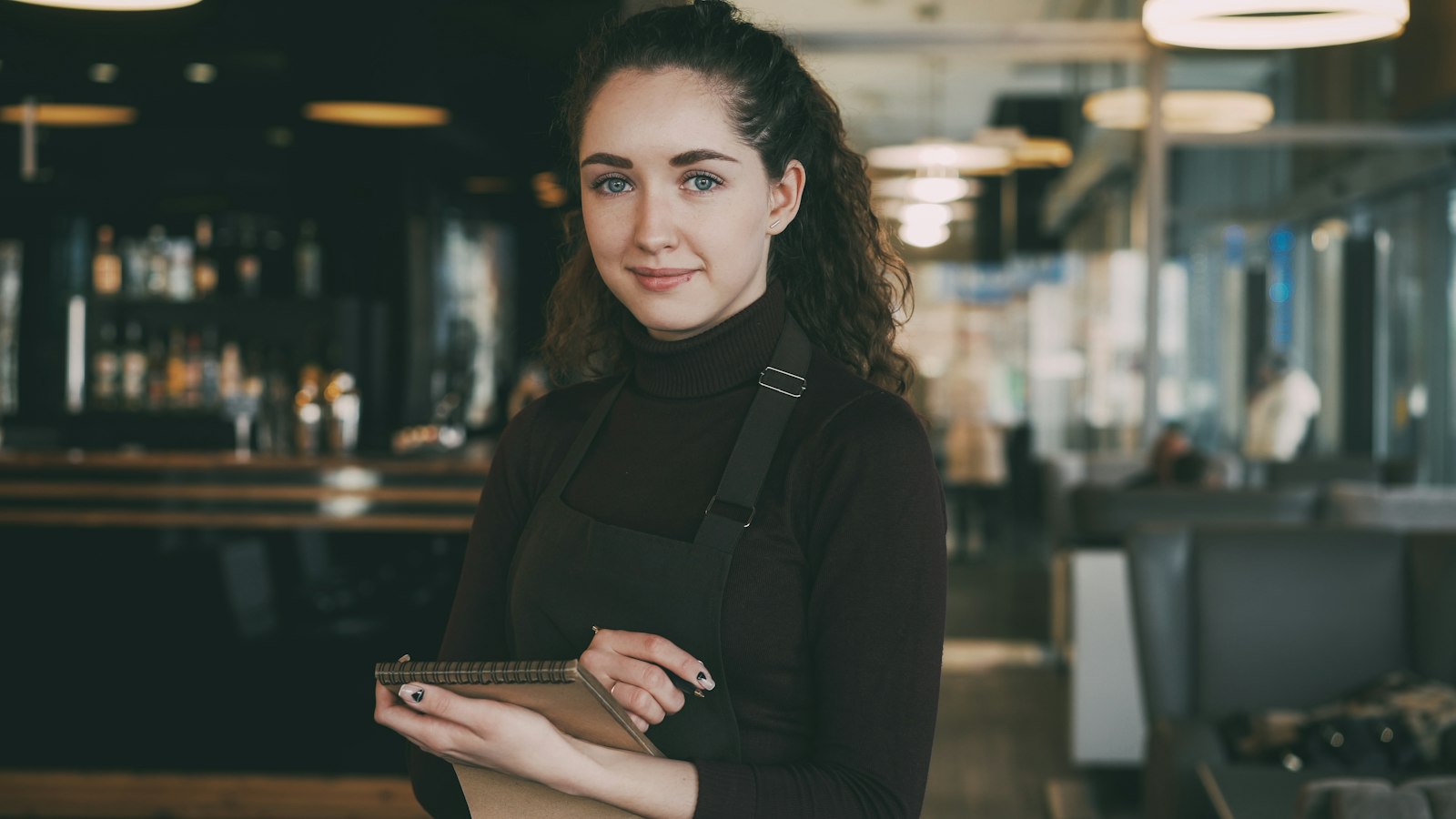 Smiling restaurant manager holding a notebook